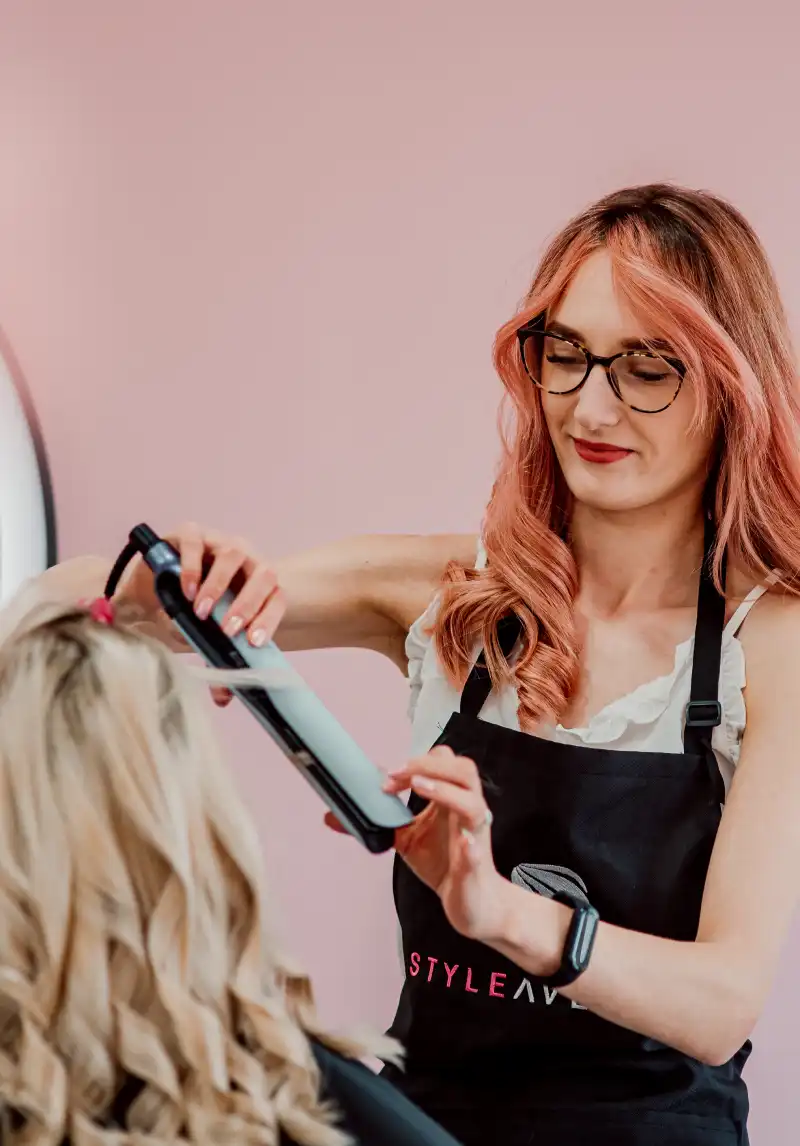 hairdresser straightening a client's hair with a straightener