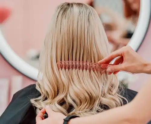 hairdresser combing a client's hair with a comb in salon in Staines