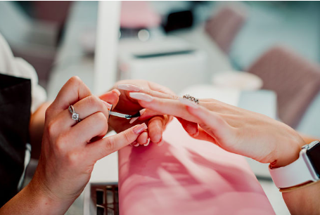beautician painting a client's nails